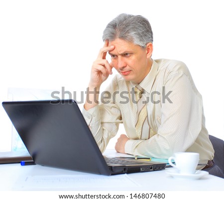 The businessman at the age of works for the laptop. Isolated on a white background.