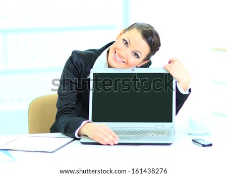 Beautiful business woman in the office, presentation of the laptop.