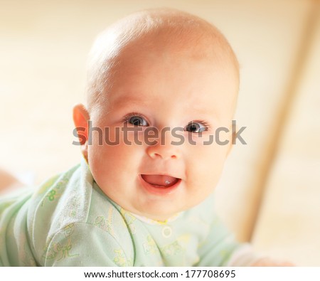 A Cute Baby Girl In Fairy Wings Laughs While Looking Up At The Camera.