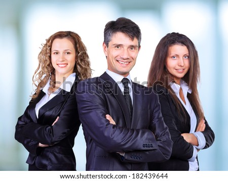 A business team with pretty leader in front looking at camera and smiling