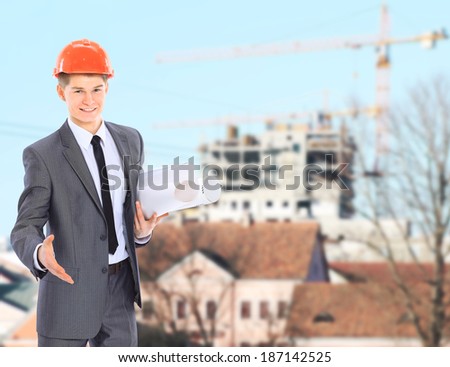 Engineer With Red Hard Hat and Blueprint Under the Power Lines.Engineer holding blueprints at an electrical substation.