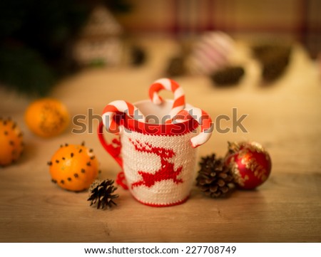 insulated wool cloth mug with embroidered deer on the wooden table mug with tangerines and a candy