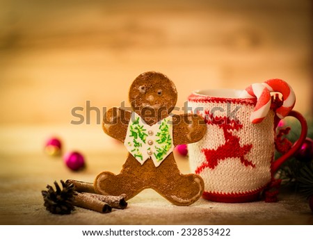 Christmas mug with decorations and sweets on wooden background