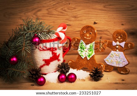 Christmas mug with Christmas decorations and cookies in the shape of a man on a wooden background