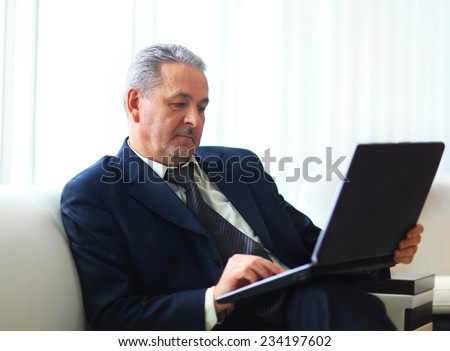 businessman in office with laptop sits and works