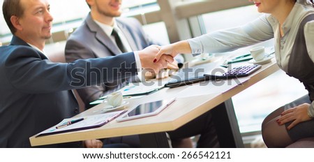Business handshake. Handshake of two business men closing a deal at the office