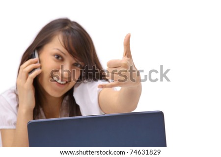 Portrait of a young woman phoning in front of a laptop computer