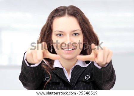 Beautiful businesswoman shows a forward index fingers in the office.