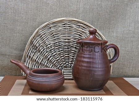 Clay jar and clay ladle standing on table