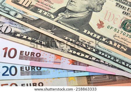 Fanned out banknotes of euros and dollars. Closeup.