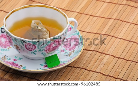Beautiful cup of of healthy green tea on a bamboo tray