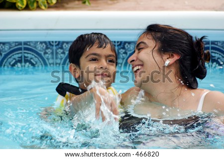 Mother and son having a great time in the pool. Shallow DOF.
