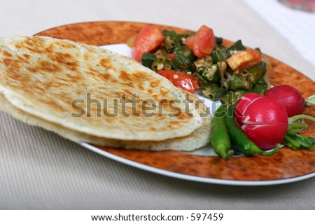 Traditional Indian meal of flat breads (rotis), okra (bhindi) and radishes. Chillies and pickles are essentials on the side.