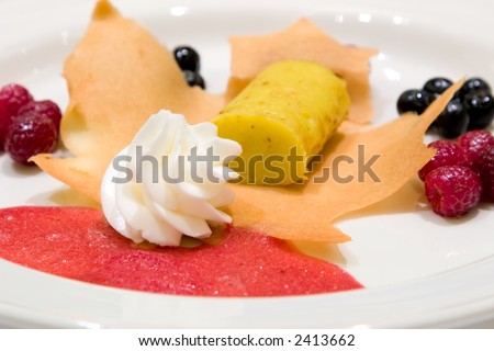Lemon custard on a tuile. Served with ice cream, fresh berries and a strawberry coulis.