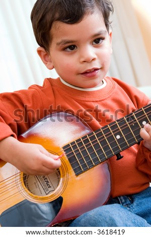 A child practices playing the guitar
