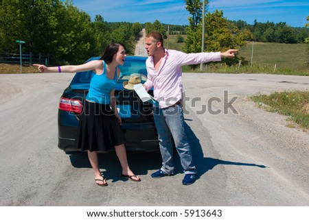 A young couple at a crossroad argue on which way to go