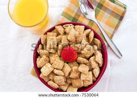Breakfast Series - A nutritious bowl of shredded wheat squares & strawberries, orange juice and bananas.