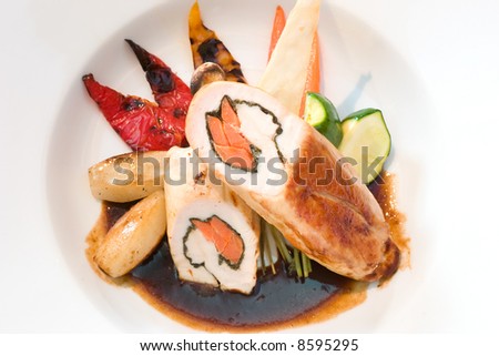 Exotic dish of stuffed turkey served with peppers, potatoes and carrots in dark sauce