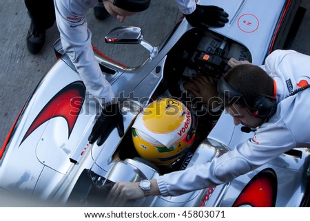 VALENCIA, SPAIN - FEBRUARY 1: Team Mclaren mechanics push Lewis Hamilton\'s car during the first F1 test on February 1, 2010 in Cheste, Valencia, Spain