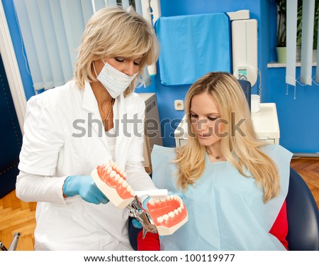 woman dentist demonstrate how to brush your teeth properly to patient