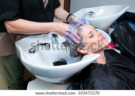 attractive woman getting her hair washed at hair salon