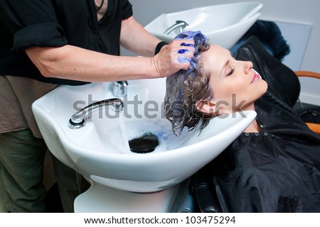 attractive woman getting her hair washed at hair salon