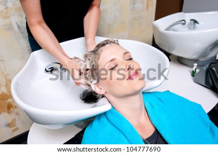attractive woman having her hair washed in salon