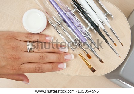 woman manicured nails with set of manicure tool brushes
