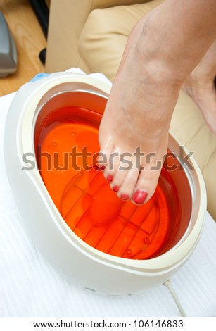 woman foot in paraffin bath beauty pedicure treatment