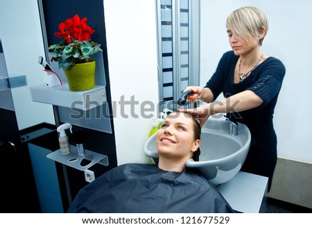 hair stylist washing woman hair in salon