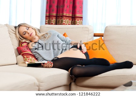 attractive blond woman slept on the sofa while reading book