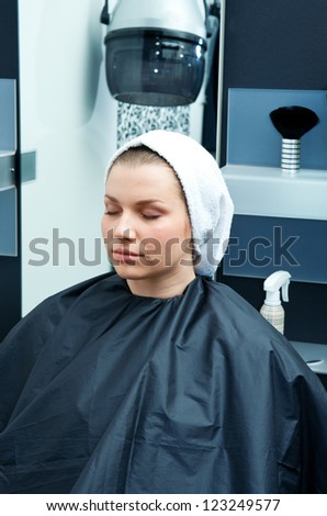 attractive woman in hair salon drying her hair with towel on her head