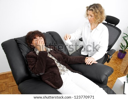 upset mature woman in therapy laying in psychiatrist office chair