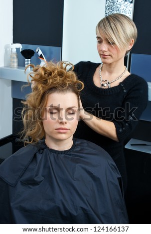 hair stylist working on woman hair in salon