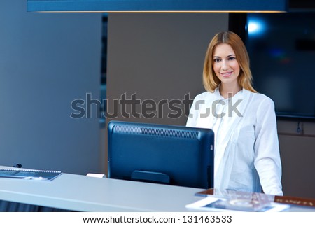 attractive woman at reception desk looking at camera