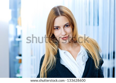 beauty portrait of natural looking blond woman with long hair and light make up indoor