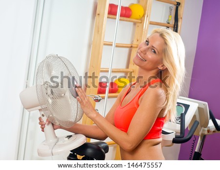 attractive woman cooling herself with electric fan
