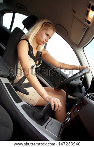 attractive woman in driver sit of the car with angry expression
