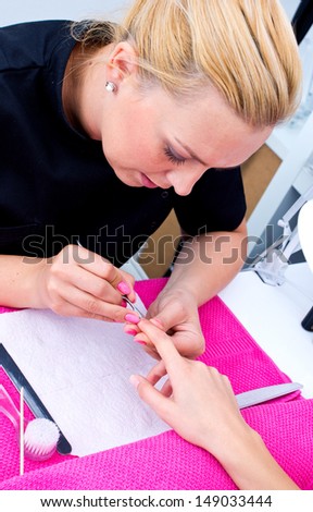woman hand on manicure treatment with cuticle knife in beauty salon