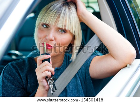 attractive blond woman with car key in driver seat exited