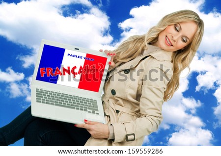 attractive woman holding laptop with french language sign on the screen