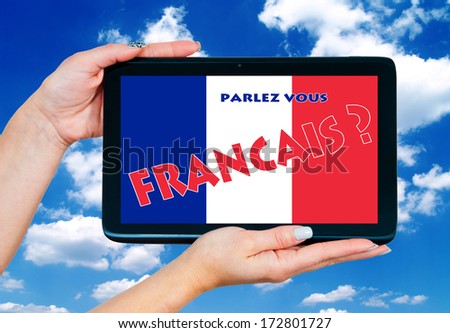 woman hands holding tablet with french language sign on the screen and blue sky in background
