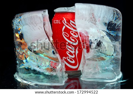 ZAGREB , CROATIA - JANUARY 24 ,2014 :   coca-cola can splashed with water in block of ice on black background, product shot