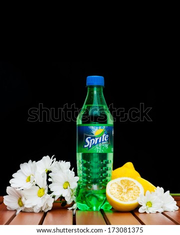 ZAGREB , CROATIA - JANUARY 24 ,2014 :  plastic bottle of soft drink sprite by coca-cola company on black background with lemon and flowers  product shot