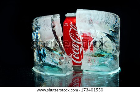 ZAGREB , CROATIA - JANUARY 24 ,2014 :  Coca cola can in the block of ice splashed with water, product shot