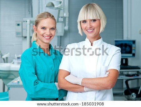 woman doctor gynecologist or oncologist with her assistant smiling in her office