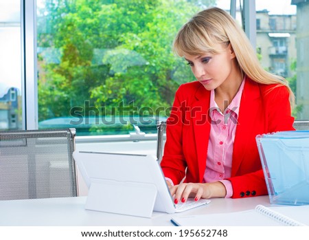 attractive blonde business woman in office with laptop computer