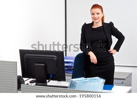 attractive modern red hair businesswoman  in small office cubicle workstation