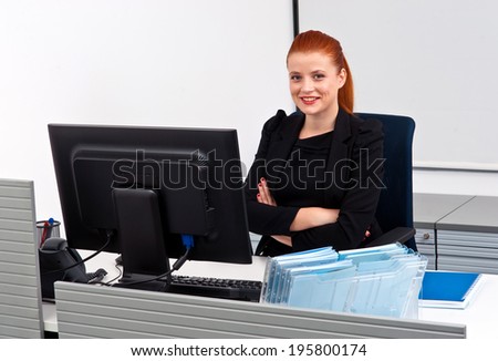 attractive modern red hair businesswoman  in small office cubicle workstation