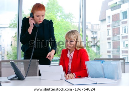 two nervous woman colleague workers in office working on laptop computer